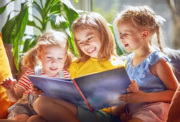 کودک در حال خواندن کتاب با لبخند