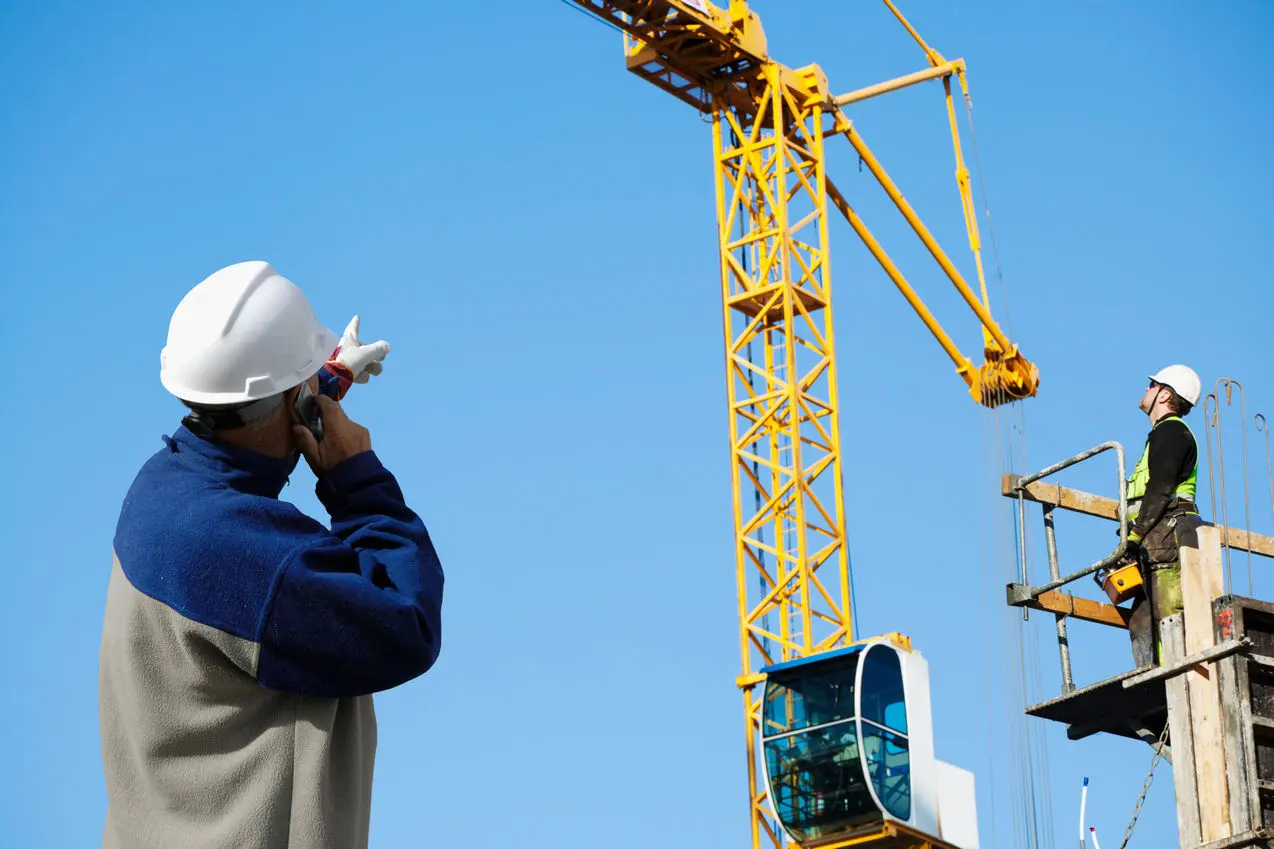 اپراتور تاورکرین در حال کنترل دستگاه در یک سایت ساخت‌وساز