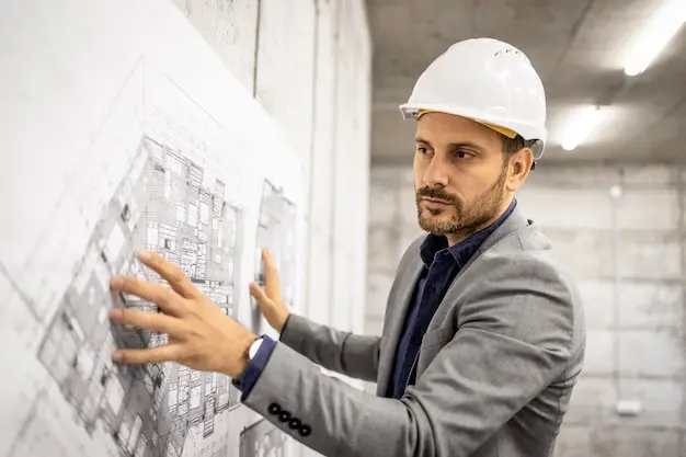 مهندس ناظر در حال بررسی نقشههای پروژه و بررسی جزئیات فنی