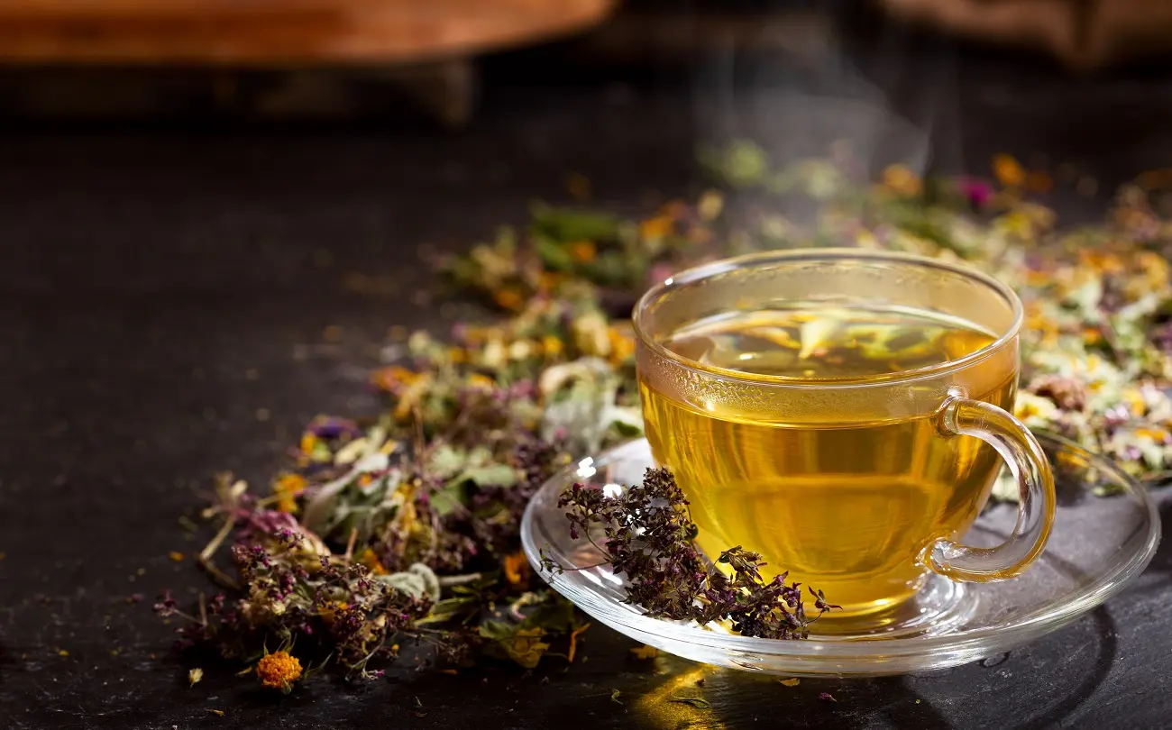 لیمو تازه و گیاهان دارویی مانند زردچوبه، دارچین و آویشن در یک سینی چوبی