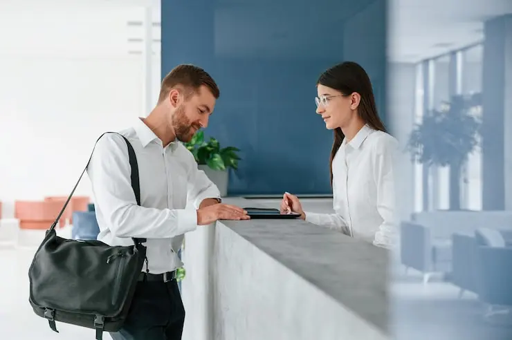 منشی هتل در حال ارائه خدمات به مهمان